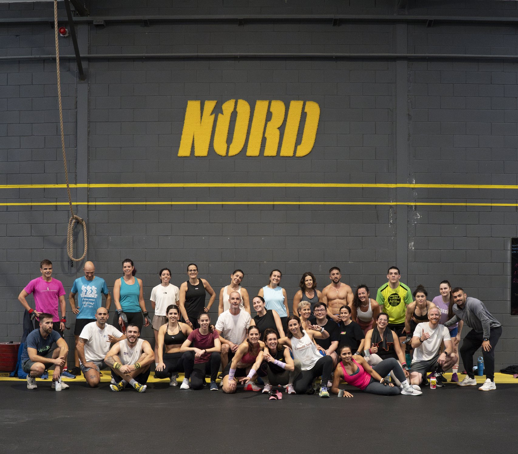 Grup d'atletes de NORD CrossFit davant del logo del box
